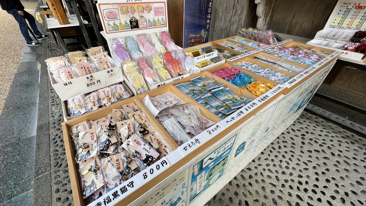 青島神社の授与所にある多種多様なお守りが並ぶ棚 カラー豊富な授与品が整列している