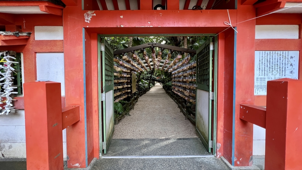 祈りの古道の入口を正面から撮影した様子 絵馬が奥まで並びトンネル状に続く光景