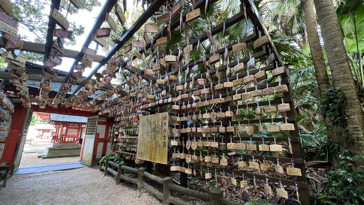祈りの古道の終点付近 無数の絵馬が左右に並び緑の中へ続く小道が見える