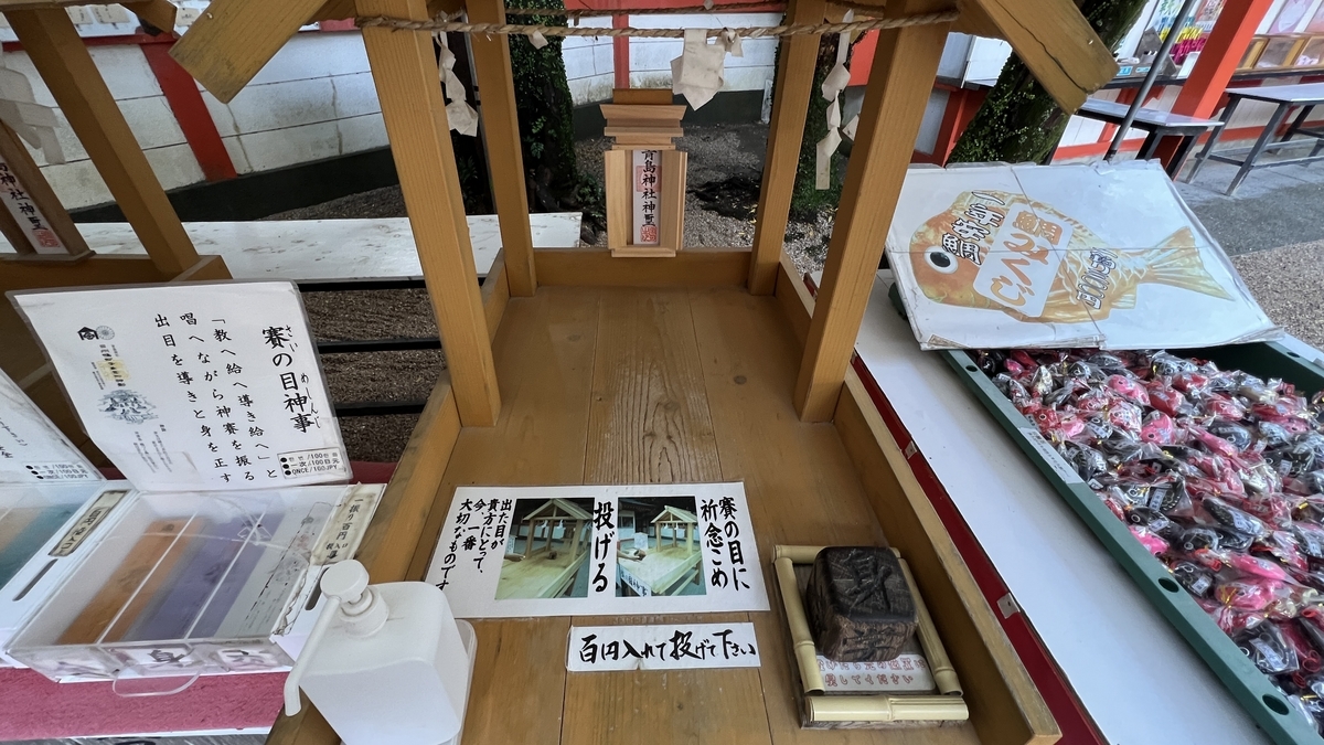 賽の目神事の案内と台が並ぶ様子 賽を振る場所と説明書きが配置されている