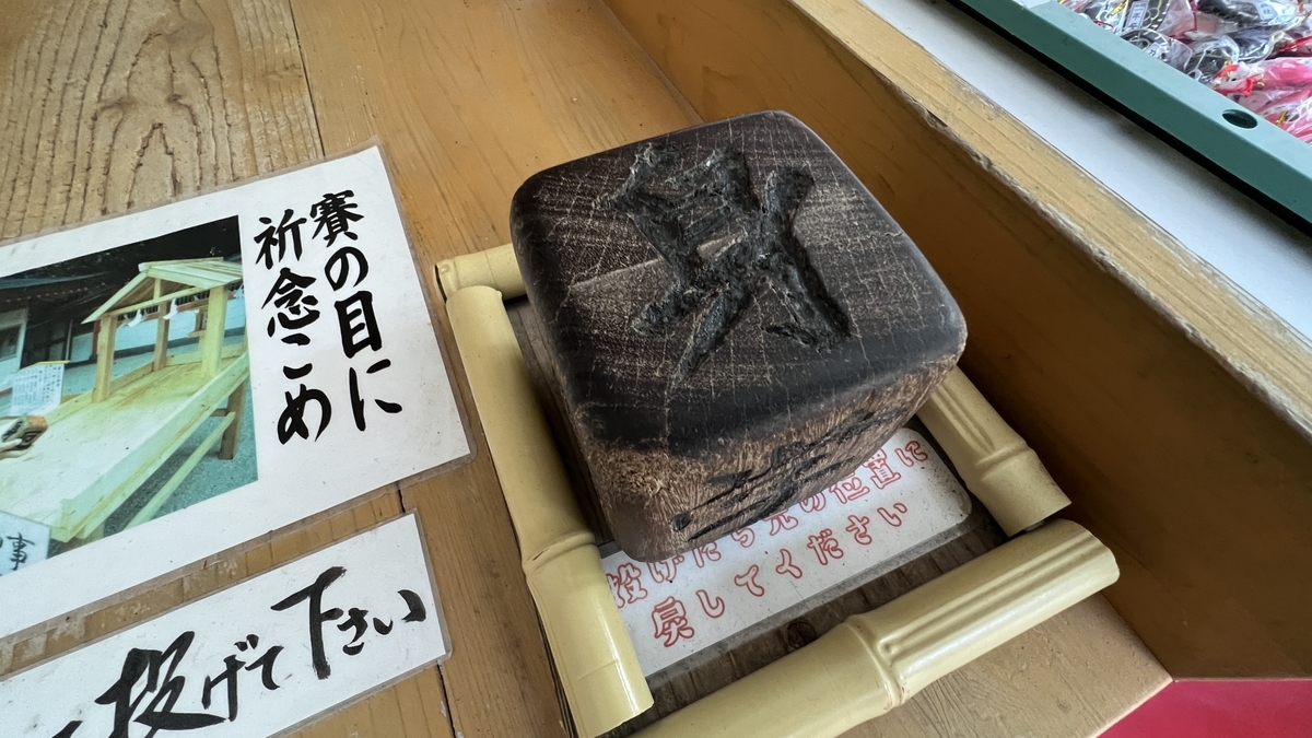 木製の賽に身学金縁交厄の文字が刻まれた賽の目神事のサイコロ