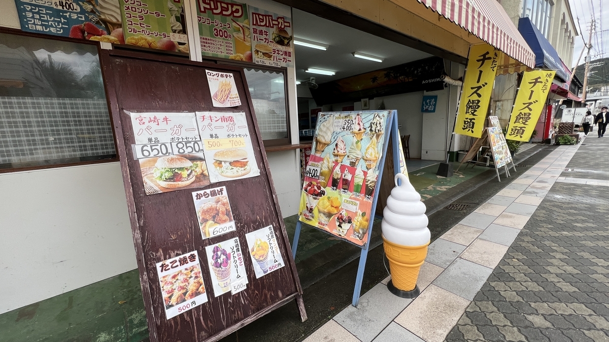 青島参道商店街の入口付近に並ぶ飲食店と看板 ソフトクリームの置物など観光地らしい雰囲気