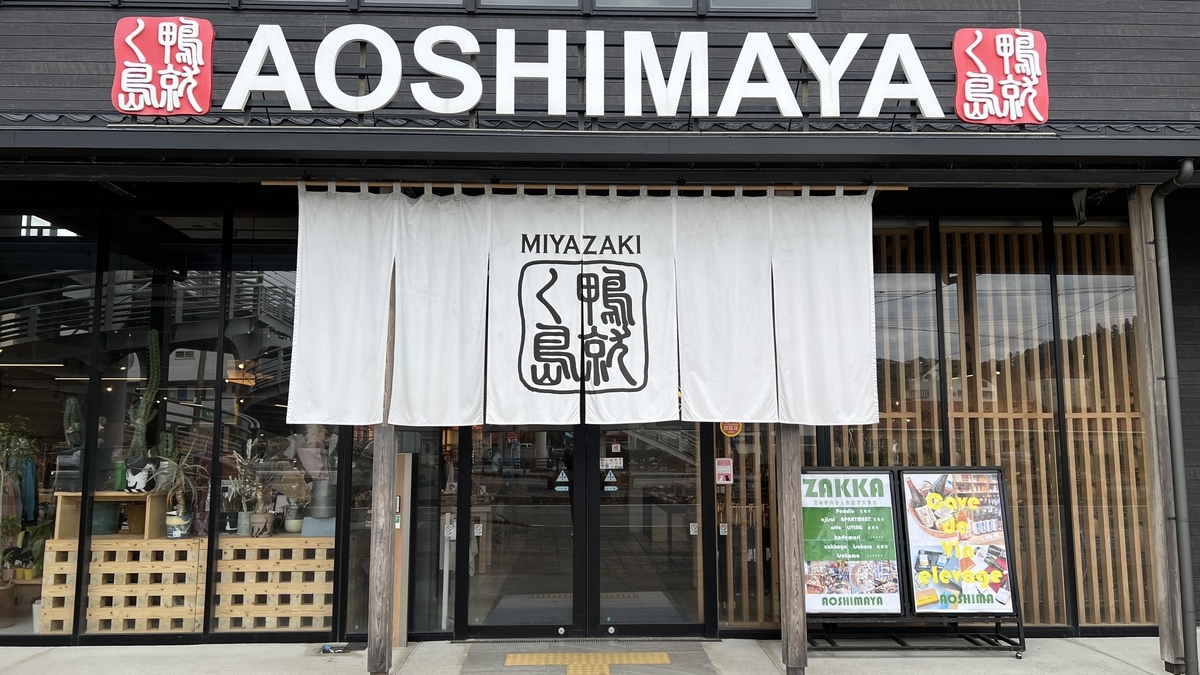 青島参道商店街の店AOSHIMAYAの入口 白い暖簾と黒い外壁が特徴の建物