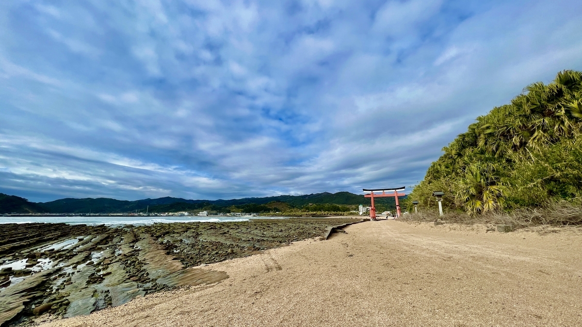青島の海岸と鬼の洗濯板が広がる風景 奥には朱色の鳥居と青い空が見える