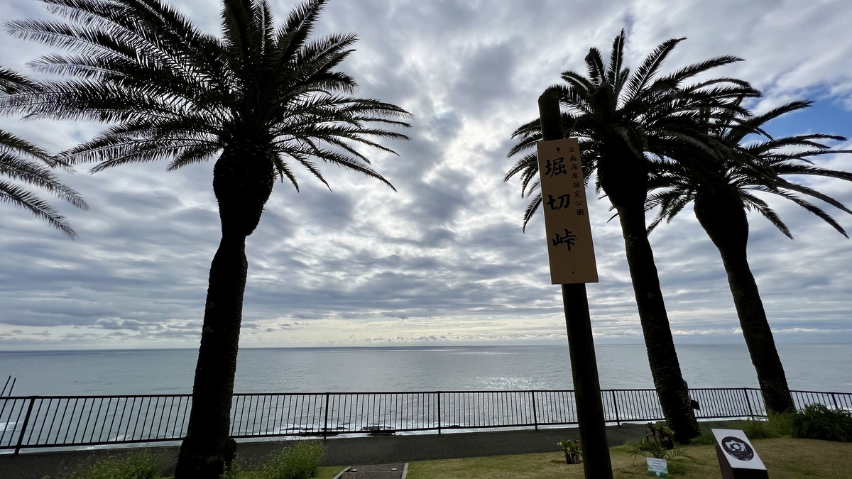 เสาหลักช่องเขาโฮริคิริ โดยมีทะเลและต้นปาล์มเป็นฉากหลัง