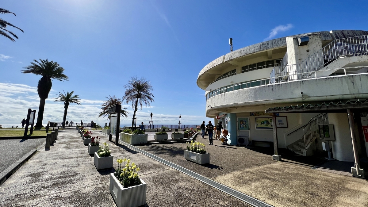 海沿いの高台に建つ道の駅フェニックスの建物と青空が広がる風景