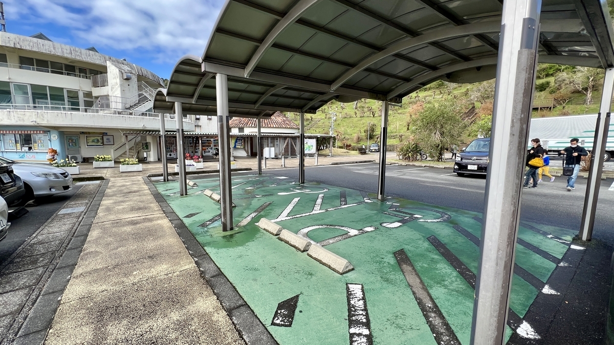 駐車スペース越しに見える高台と海岸の風景