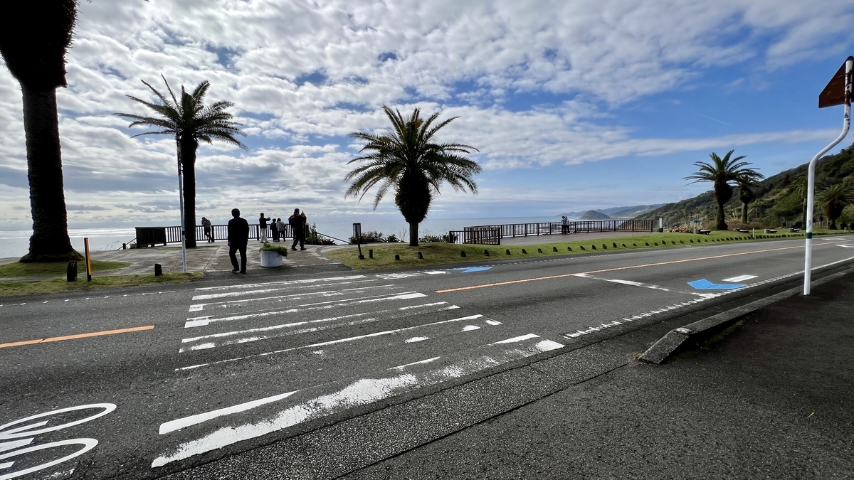 道路沿いの横断歩道とその先に見える展望デッキへの入り口