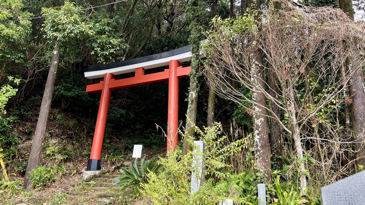 เสาโทริอิสีแดงที่ทางเข้าถนนสายหลักเดิมท่ามกลางป่าเขียว