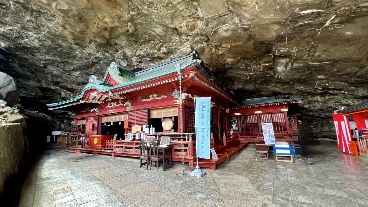 ศาลเจ้าหลักของศาลเจ้าอุโดะภายในถ้ำที่ล้อมรอบด้วยผนังหินและผู้คนที่มาสักการะ