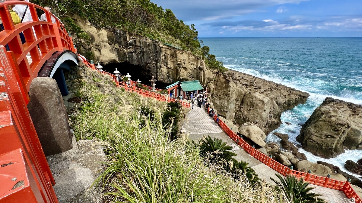 朱红色栏杆和悬崖迫近的通往本殿洞窟的参道景观