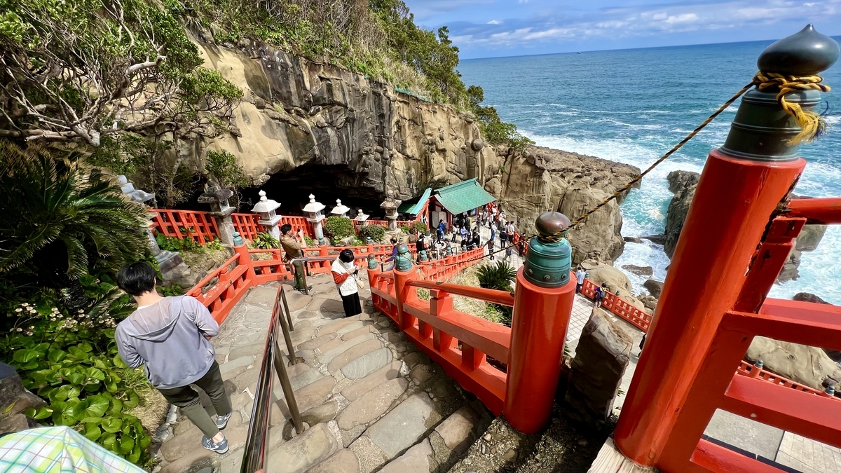 以大海和悬崖为背景下石阶的参拜者和朱红色栏杆