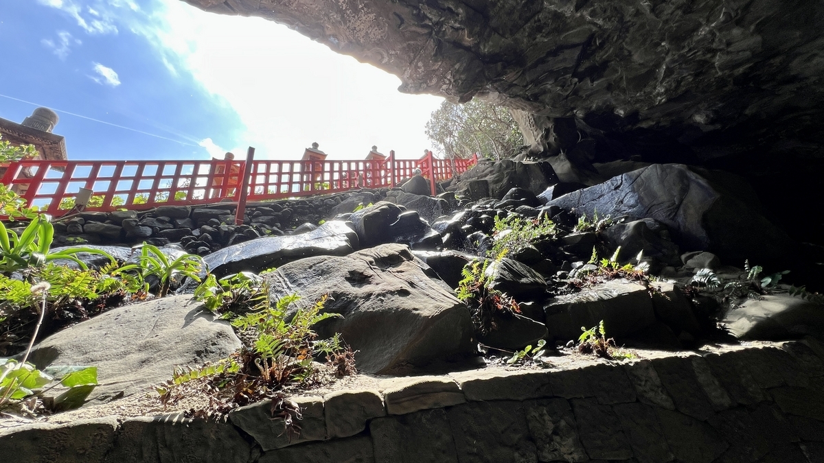 透过洞窟岩壁看到朱红色栏杆和外部光线的鹈戸神宫风景