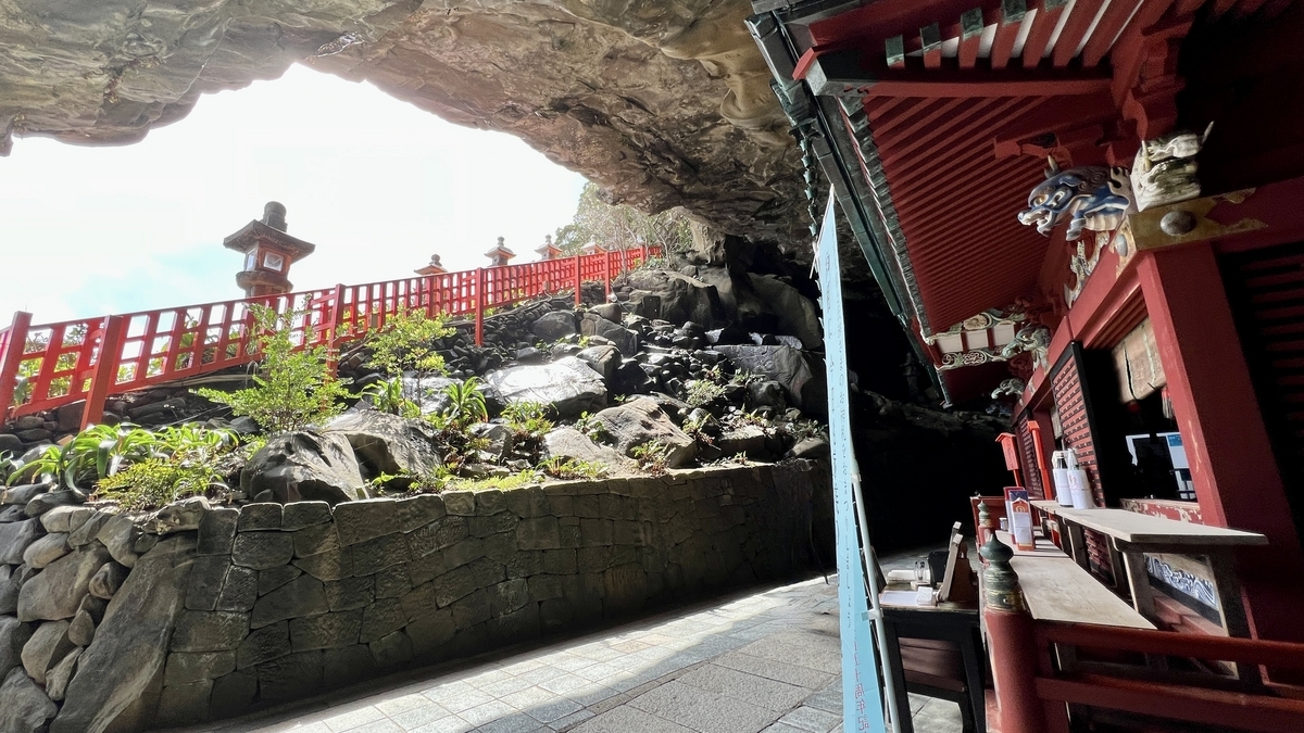 从洞窟深处眺望大海和朱红色栏杆的本殿前景色