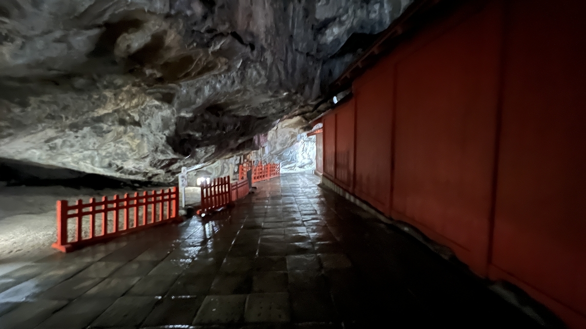 洞窟天花板低矮的本殿后方参拜通道和朱红色栅栏