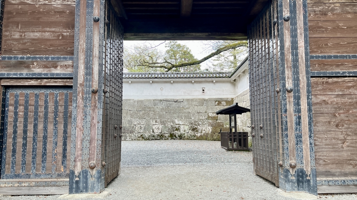 มุมมองผ่านประตูโอเตะมงปราสาทโอบิแสดงกำแพงขาวและจัตุรัสข้างหน้า