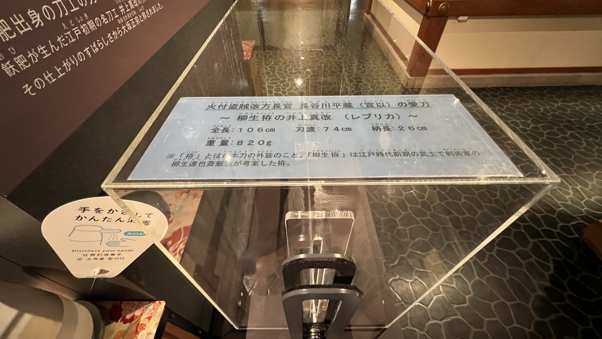 ดาบบนฐานไม้พร้อมคำอธิบายนิทรรศการ