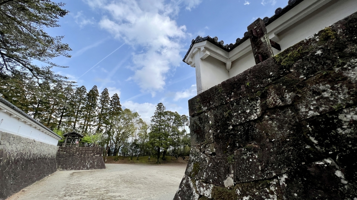 ทัศนียภาพของปราสาทโอบิพร้อมกำแพงหินปกคลุมมอส กำแพงขาว และหอระฆังด้านบน