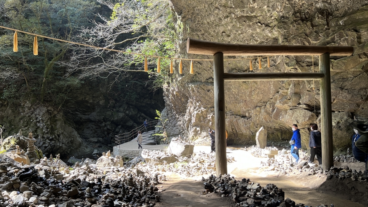 鸟居和石塔间站立的参拜者