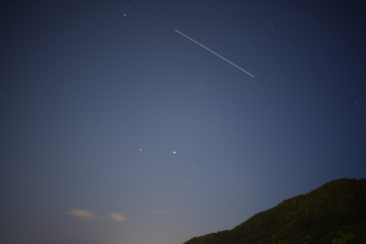 별이 빛나는 밤하늘에 일직선으로 뻗은 국제우주정거장의 통과 궤적