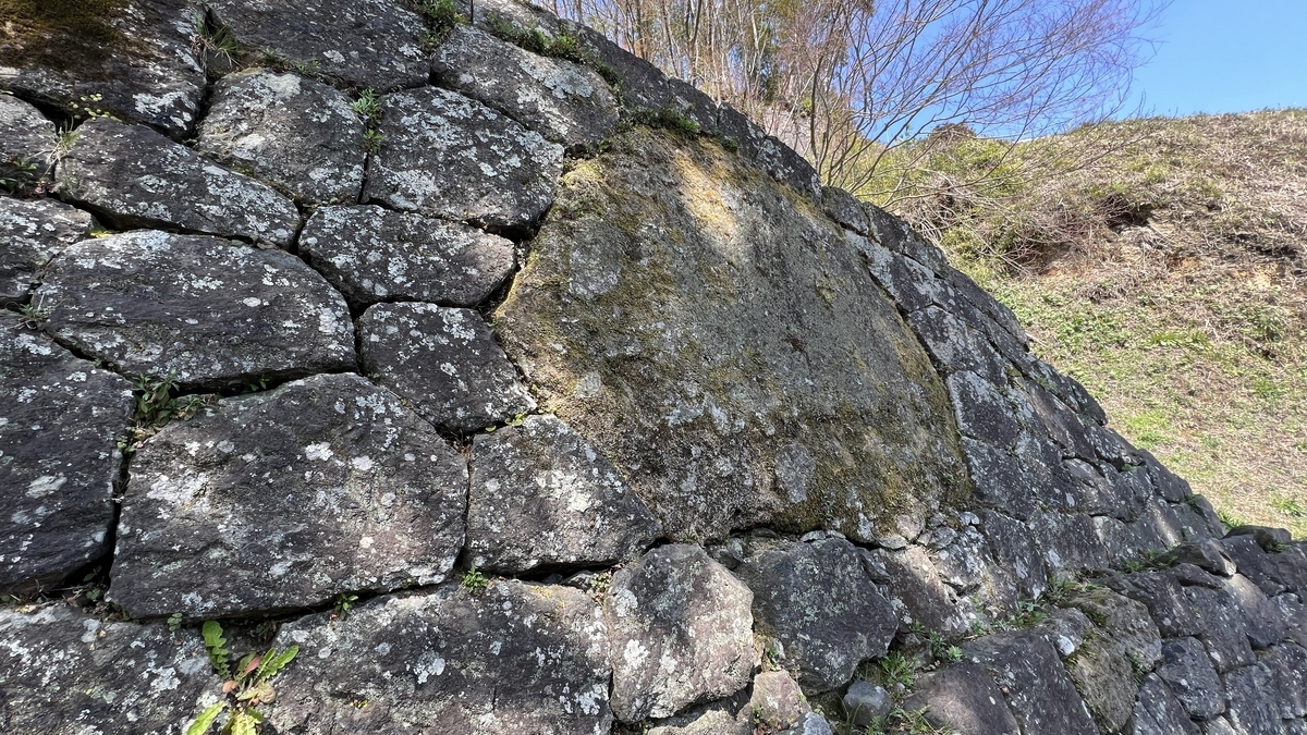 석벽에 박힌 거대한 거울돌과 주변 석조물