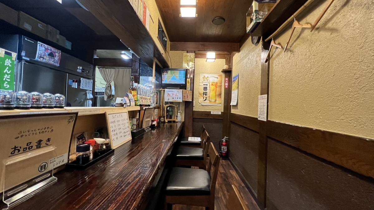 Asientos de barra con mostrador largo de madera y carteles en la pared