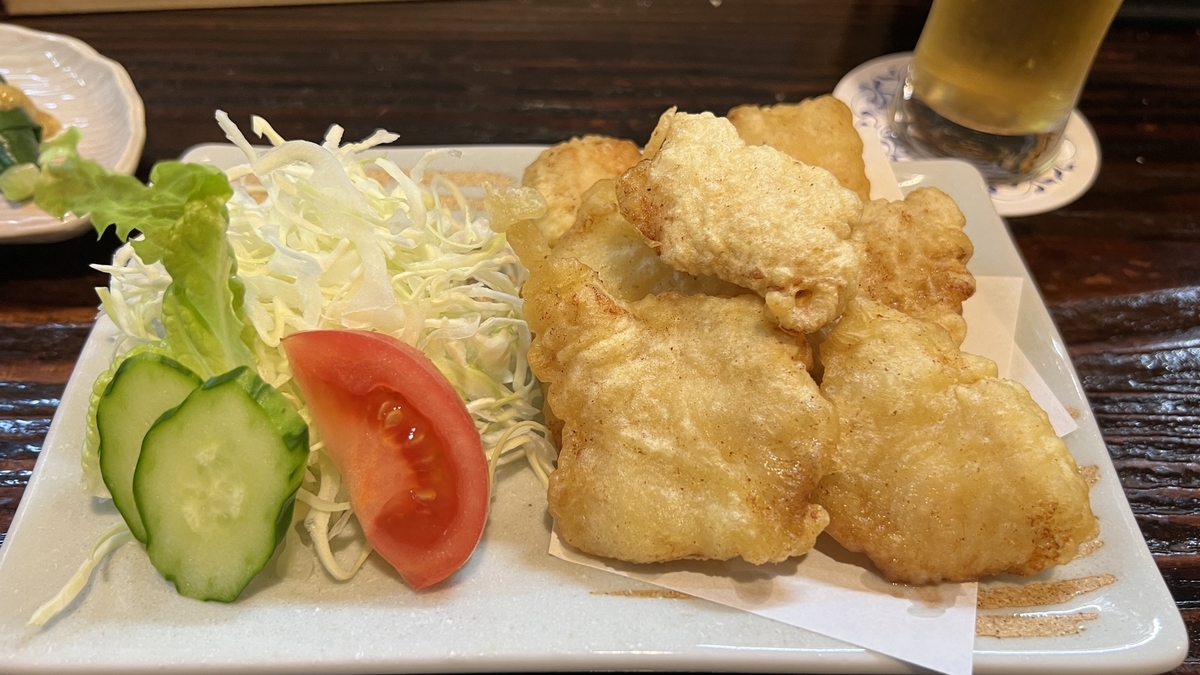 Toriten recién frito con rebozado crujiente, servido con repollo, pepino y tomate