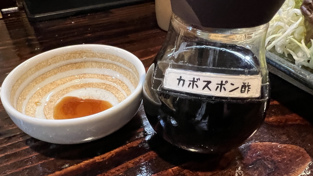 Botella de ponzu de kabosu y pequeño plato con salsa para mojar