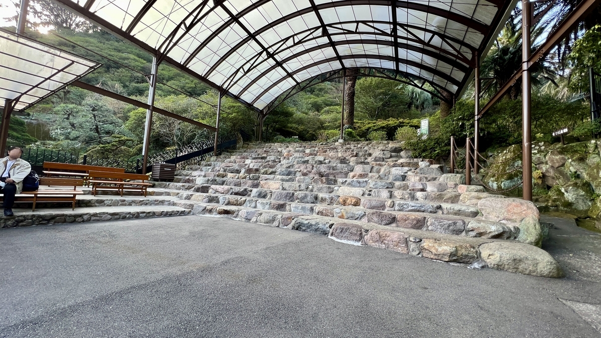 有頂棚的石階觀覽席和被綠樹環繞的等候區