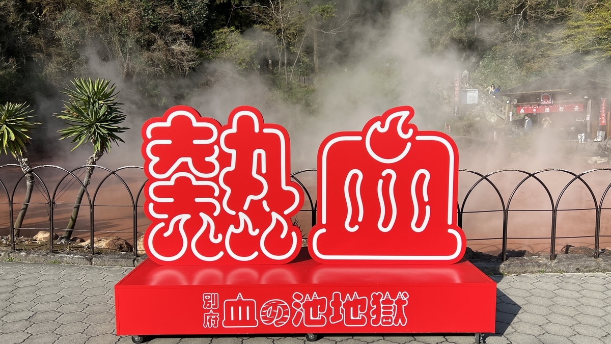 Monumento Nekketsu sobre un pedestal rojo frente a la piscina humeante