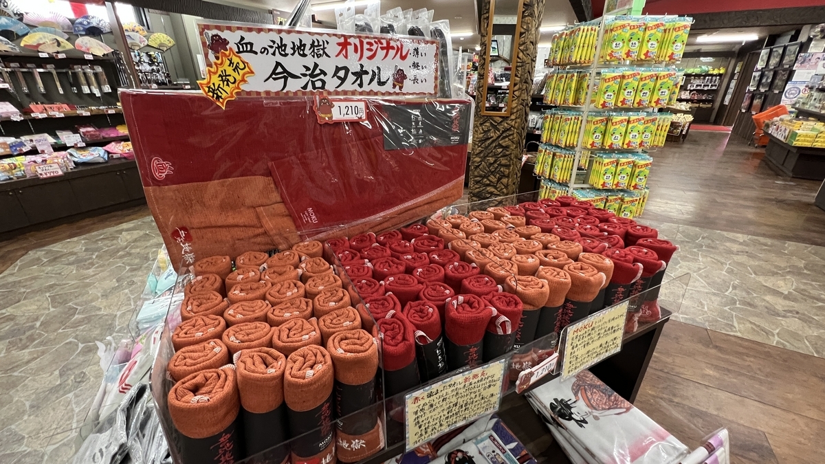 Rollos rojos y naranjas de toallas Imabari originales de Chinoike Jigoku ordenadamente exhibidos