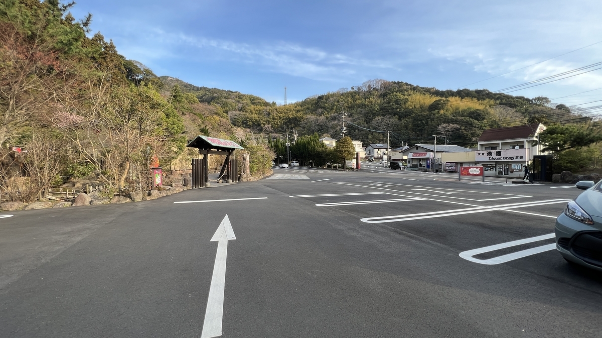Flechas de carril del estacionamiento apuntando a la puerta de entrada y tiendas al lado de la carretera