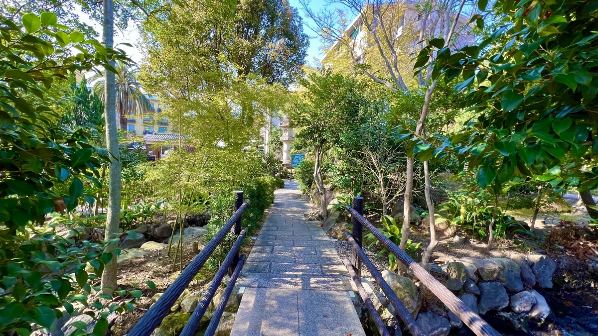 시라이케 지고쿠 일본 정원에 놓인 작은 다리와 돌로 포장된 산책로, 나무들