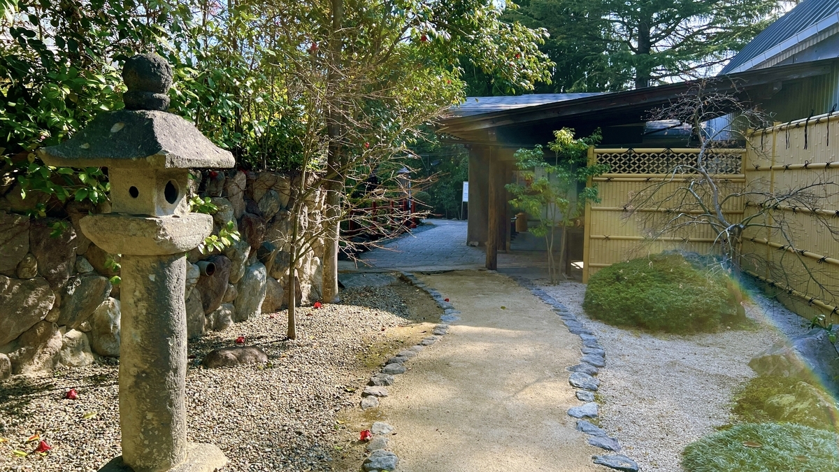 시라이케 지고쿠 일본 정원의 석등롱과 자갈 깔린 오솔길, 대나무 울타리