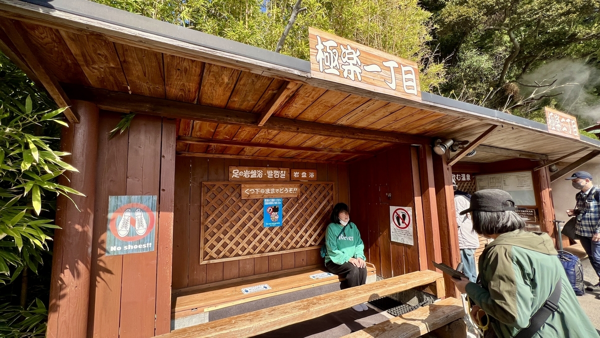 고쿠라쿠 1초메의 발 암반욕 목조 오두막과 신발을 벗고 앉은 사람