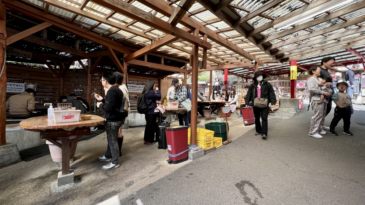 지붕 있는 족욕 구역에서 족욕과 스위츠 휴식을 즐기는 사람들