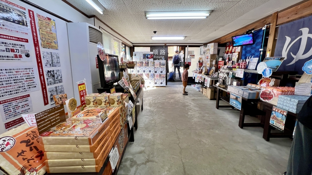 기념품 매장 중앙 통로와 벽면 가득한 안내 게시물, 상품 진열대