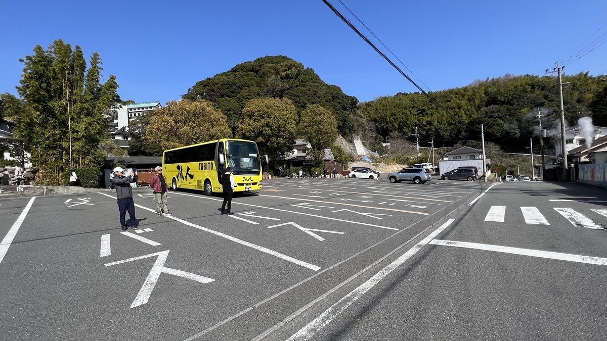 노란 관광버스가 서 있는 넓은 주차장과 산맥