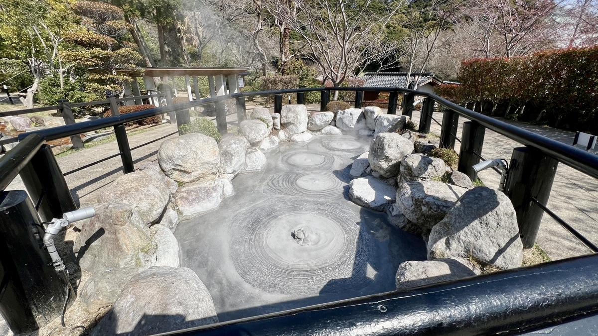 Pequeño estanque de barro con barro gris hirviente rodeado de rocas en Oniishi Bouzu Jigoku