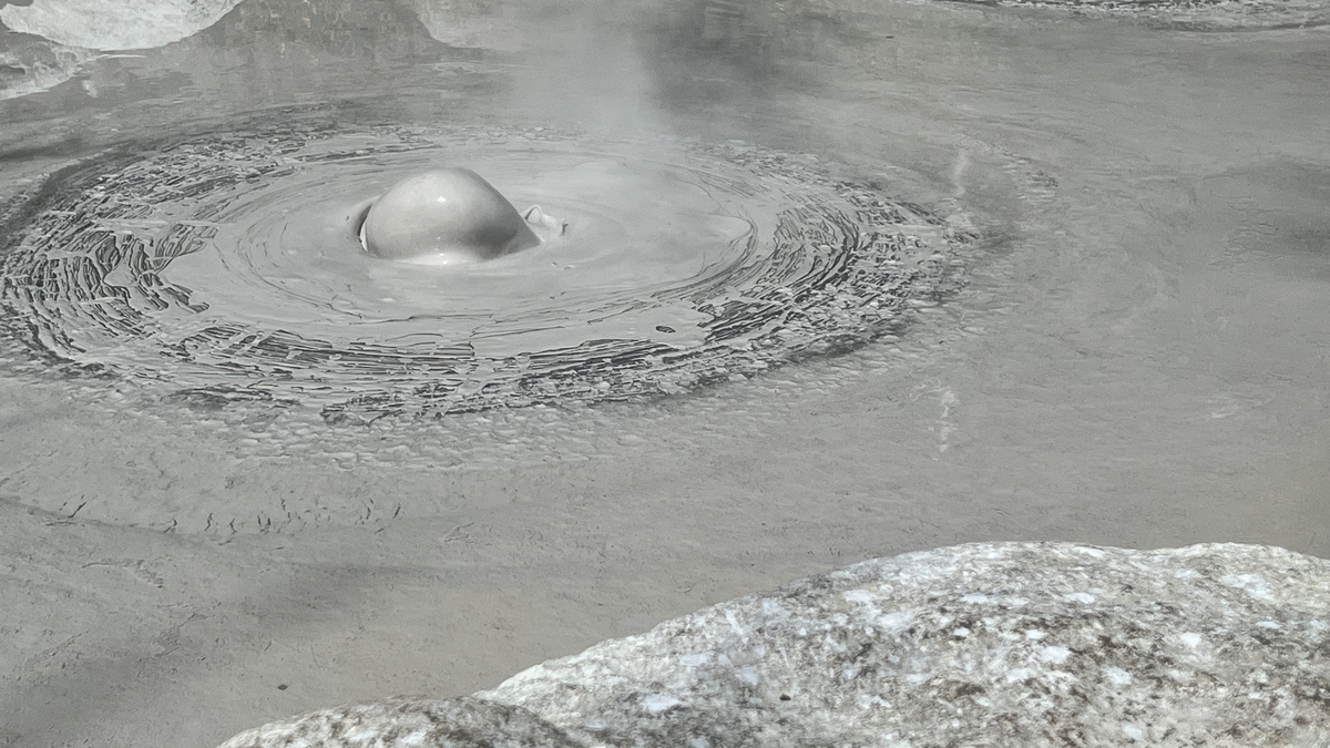Primer plano de barro caliente elevándose como una cabeza calva redonda