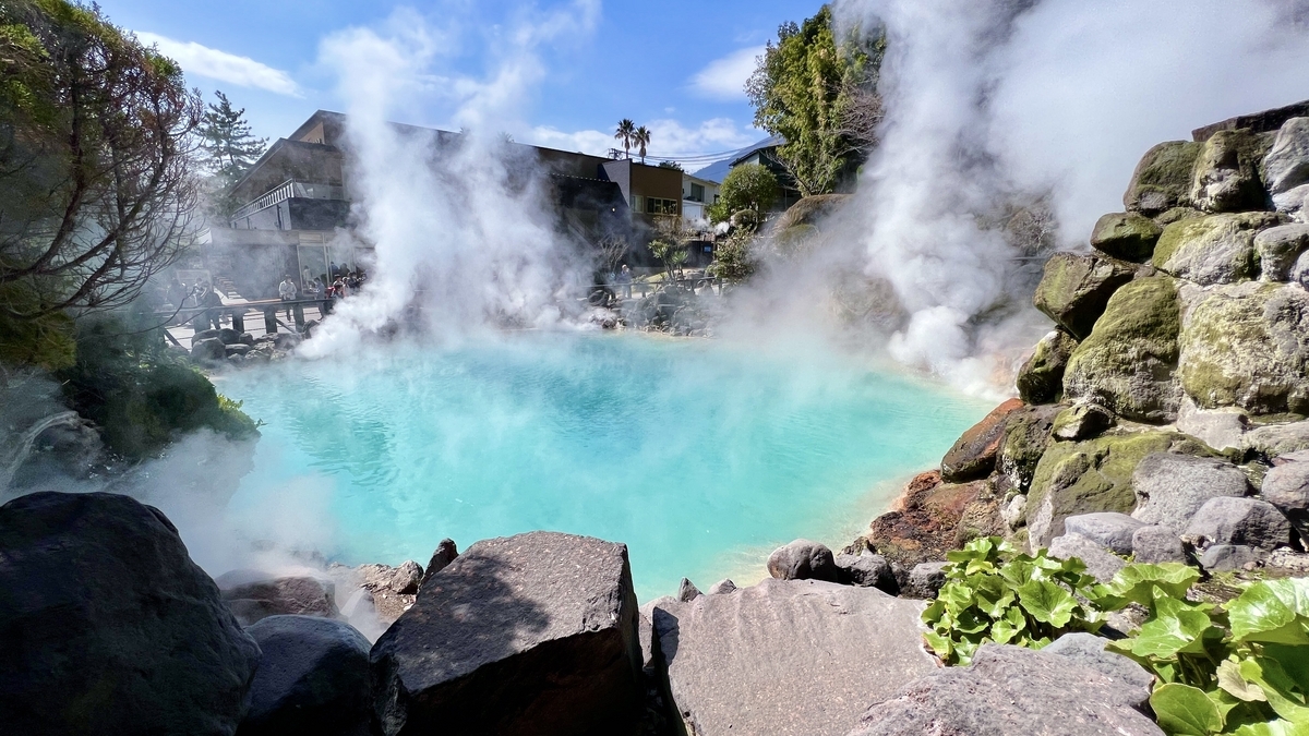 흰 수증기가 피어오르는 우미지고쿠의 코발트 블루 온천과 바위