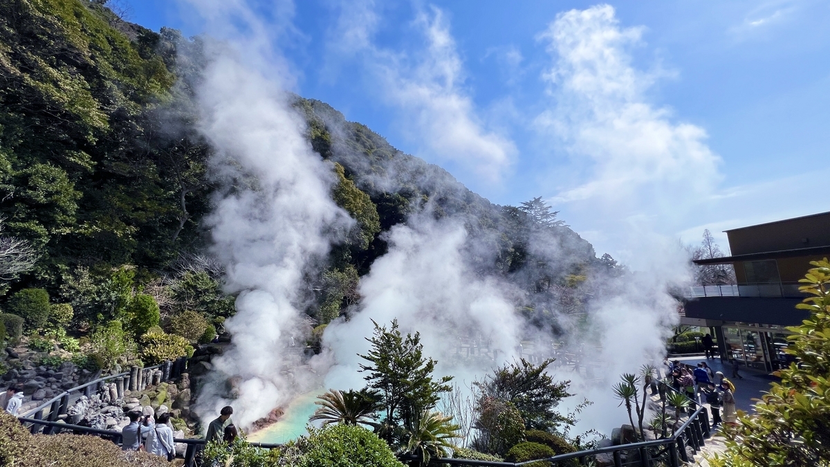 전망대에서 본 우미지고쿠의 넓은 온천 웅덩이와 초록 경사면에 피어오르는 수증기