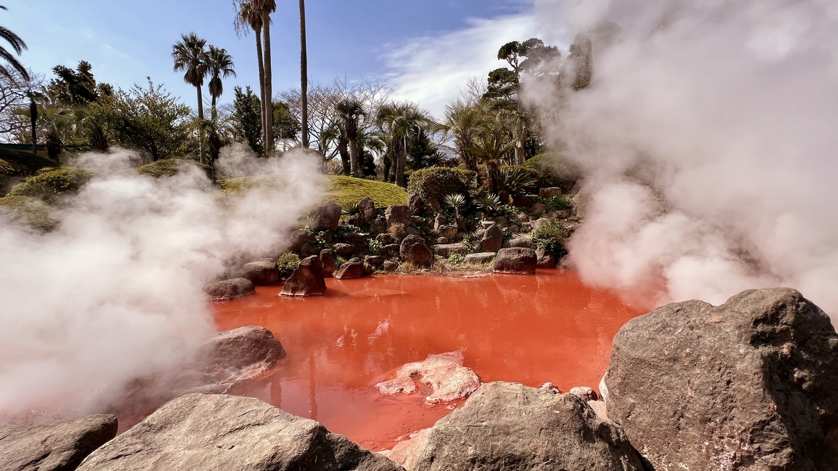 붉게 물든 아카이케지고쿠 수면과 흰 수증기에 둘러싸인 바위
