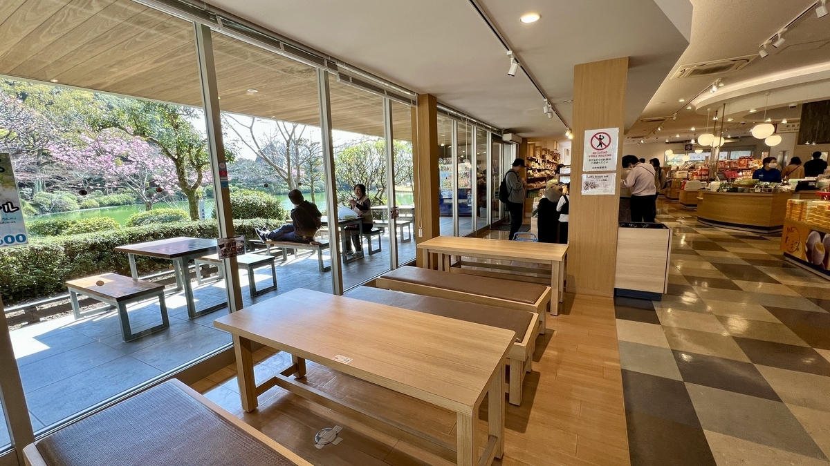 유리창가에 테이블이 놓인 숍 렌 휴식 공간과 정원 풍경