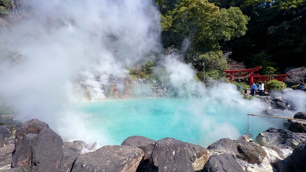 푸른 수면과 짙은 수증기가 피어오르는 우미지고쿠 풍경과 주홍색 도리이