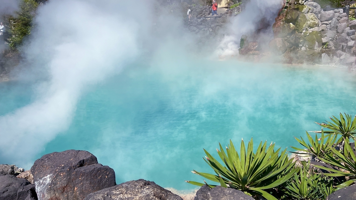 검은 바위와 녹색 식물 앞에 펼쳐진 우미지고쿠의 푸른 수면