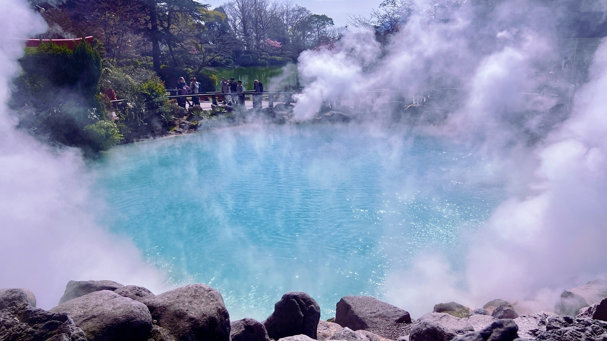 수증기 사이로 보이는 우미지고쿠의 푸른 수면과 주변 바위