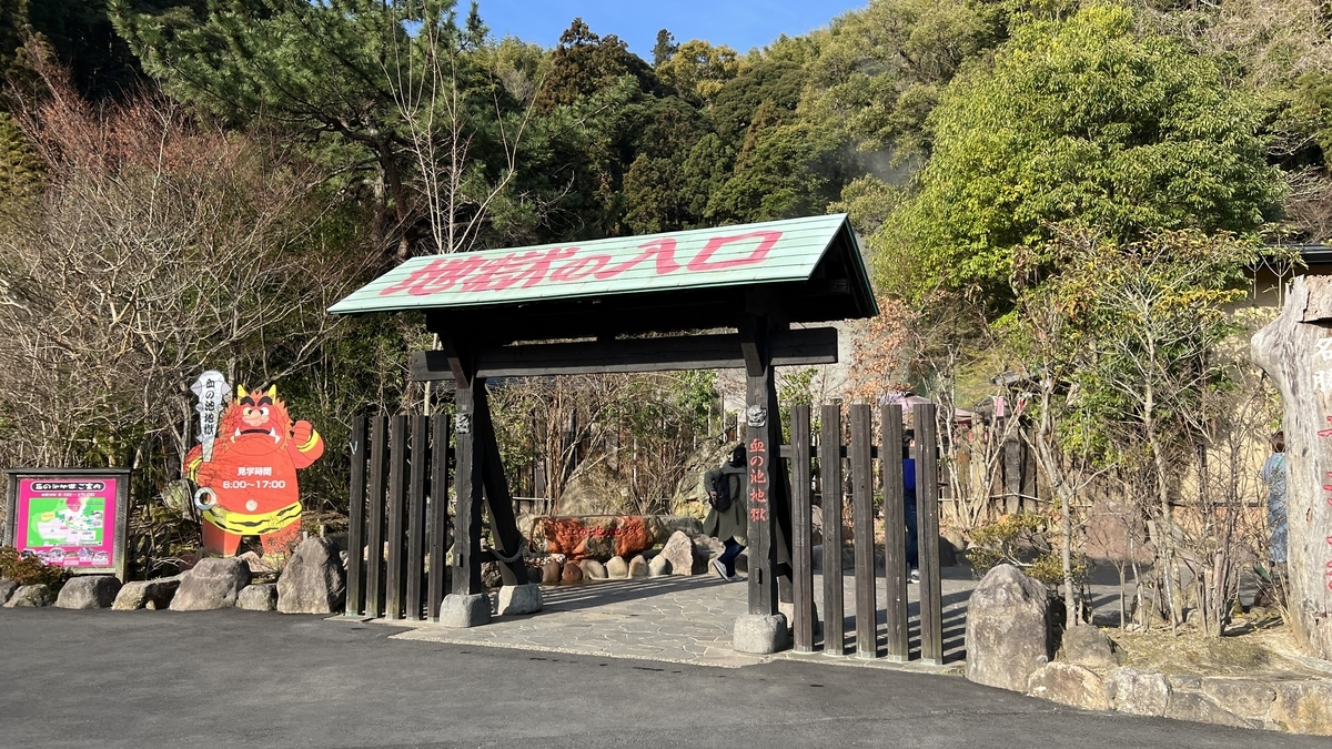 血の池地獄の入口ゲートと鬼の看板が並ぶ入場口の風景