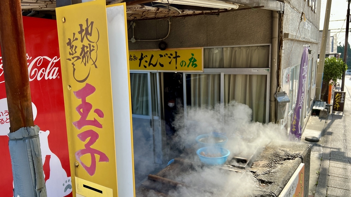 地獄蒸しの釜から蒸気が上がり温泉卵を作る湯煙の調理場