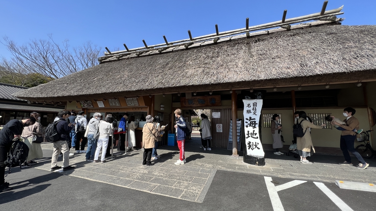 海地獄の茅葺き屋根の入口でチケット購入の行列ができる様子
